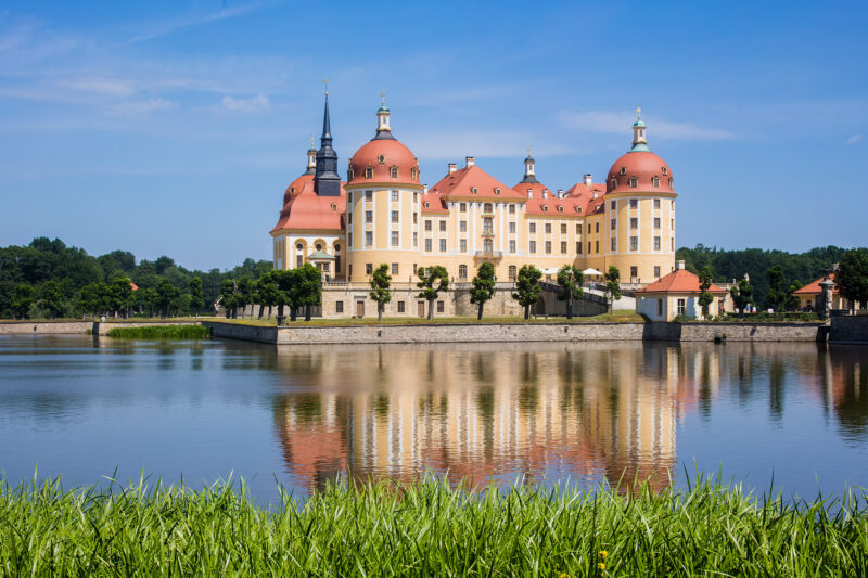 Schloss Moritzburg umgeben vom Schlossteich an einem wolkenlosen Tag - Link auf die Unterseite von Schloss Moritzburg